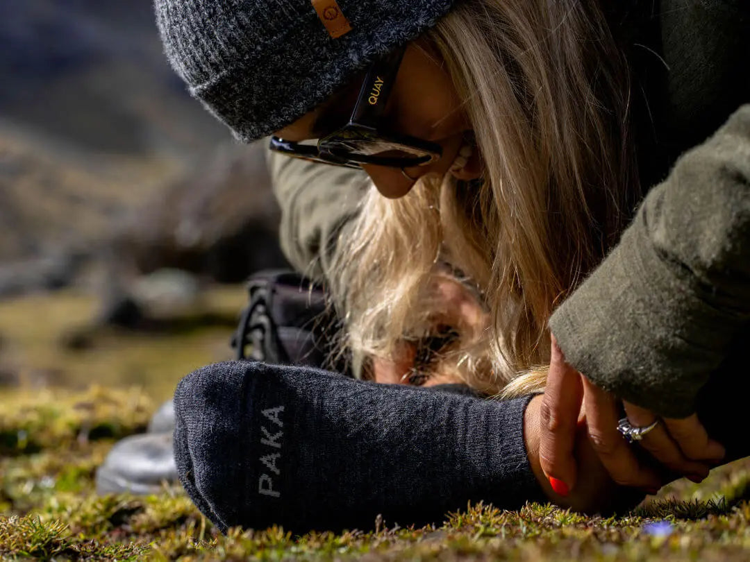 A woman admiring her new dark grey ankle socks