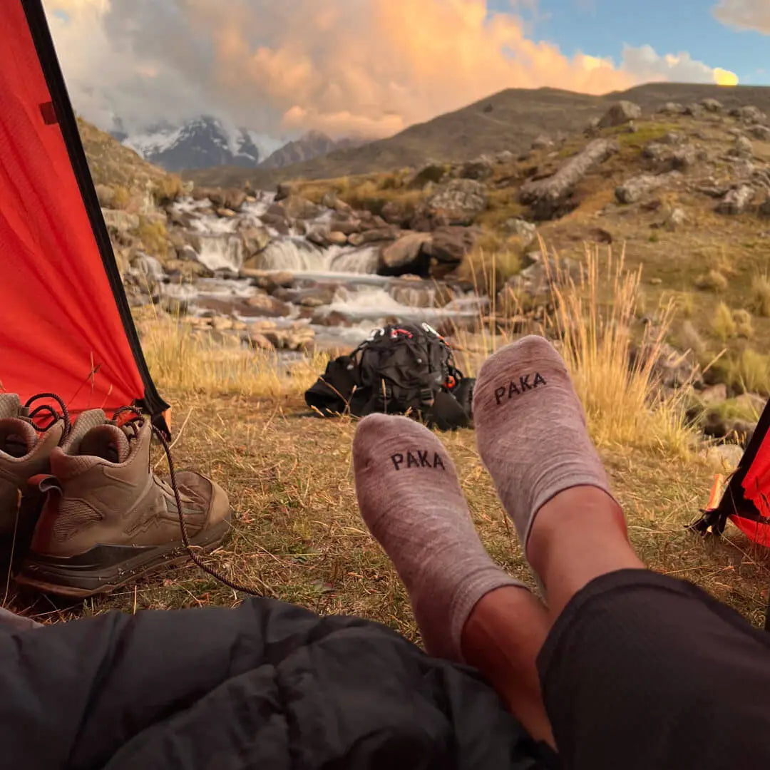A pair of cozy ankle socks worn next to a tent outdoors