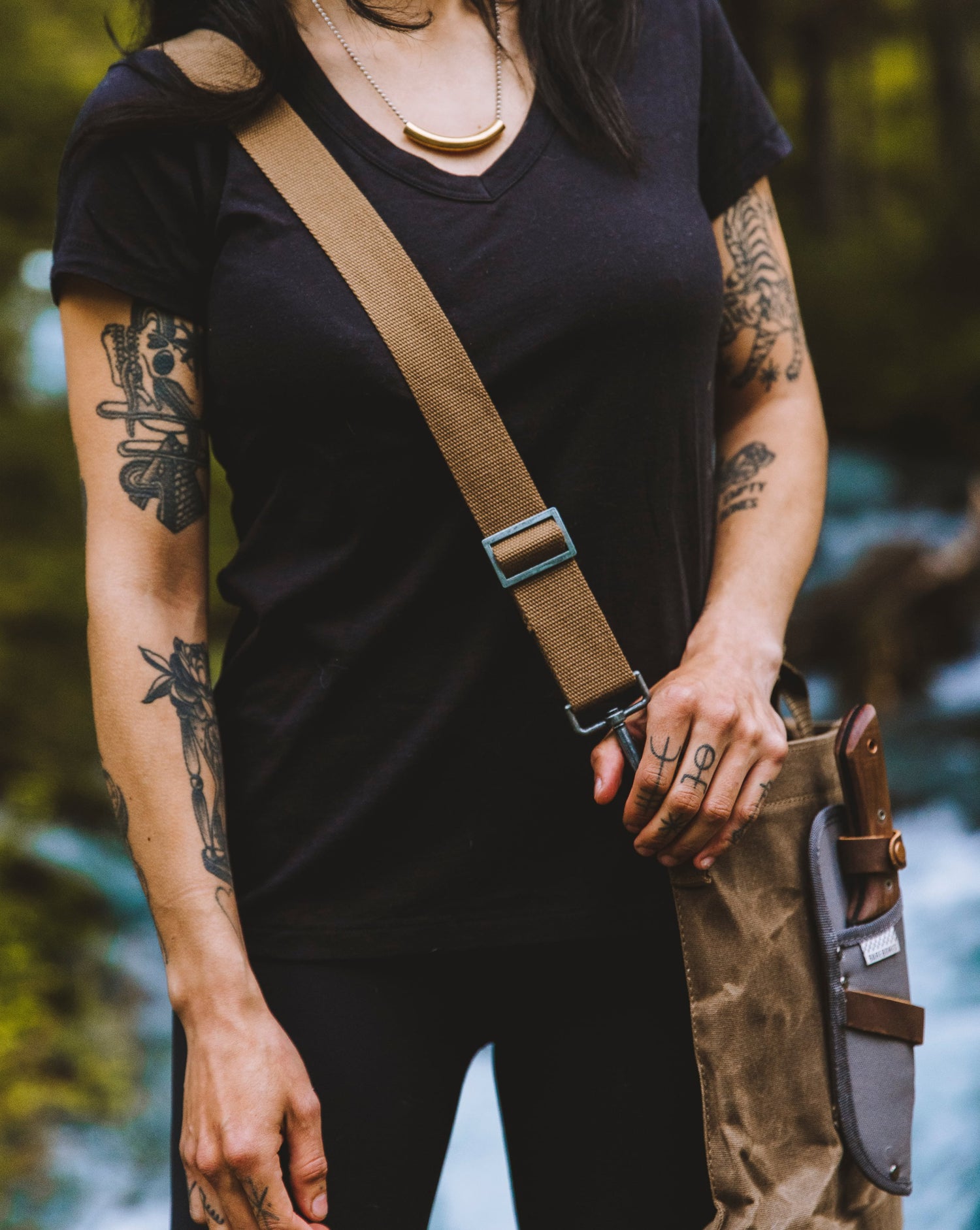 Woman in her black v-neck tee. She has some impressive tattoos on her arms