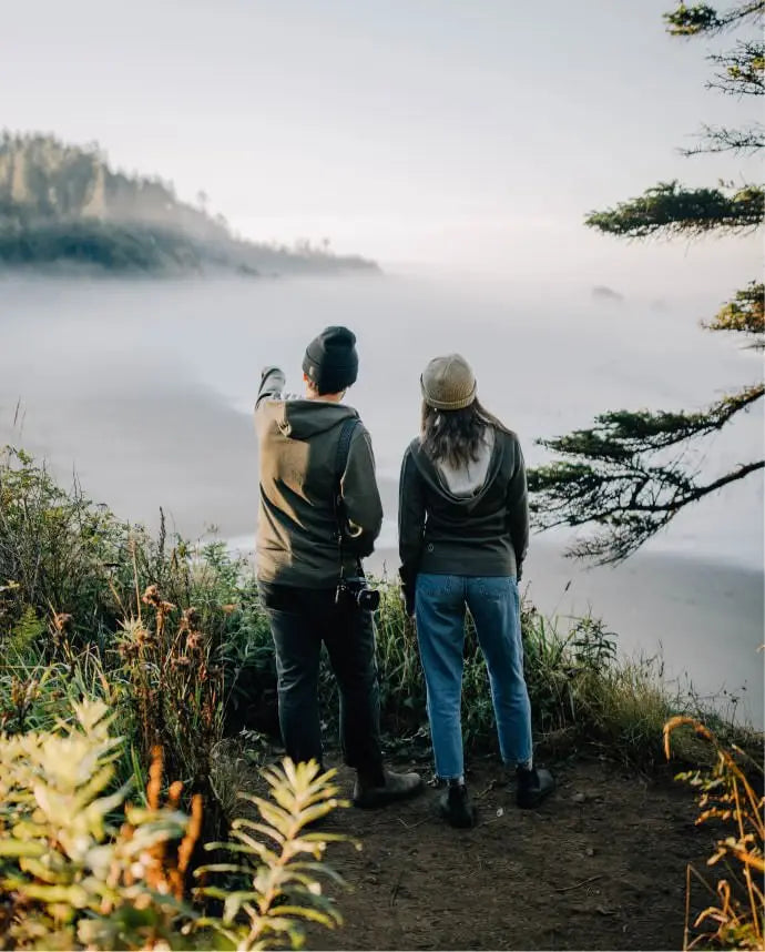 Woman and man in breathe andean moss breathe zips overlooking fog