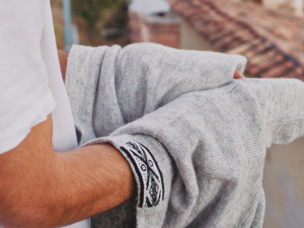 A man holding a light grey crew