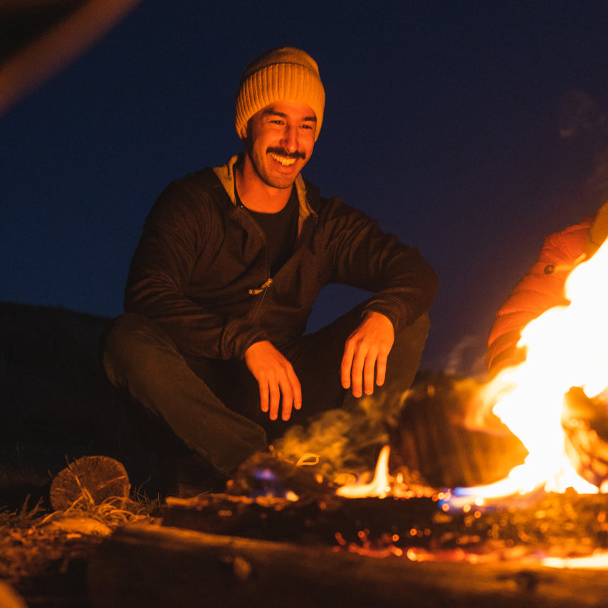 A man smiling in a campfire