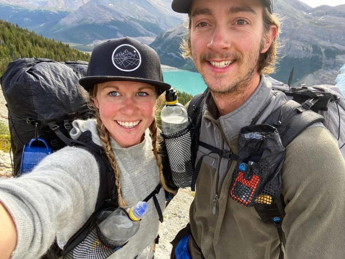 A couple taking a selfie in front of a mineral blue lake