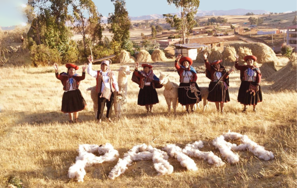 A group of Quechua weavers waving hands. In the grass it says "Paka" with alpaca fiber