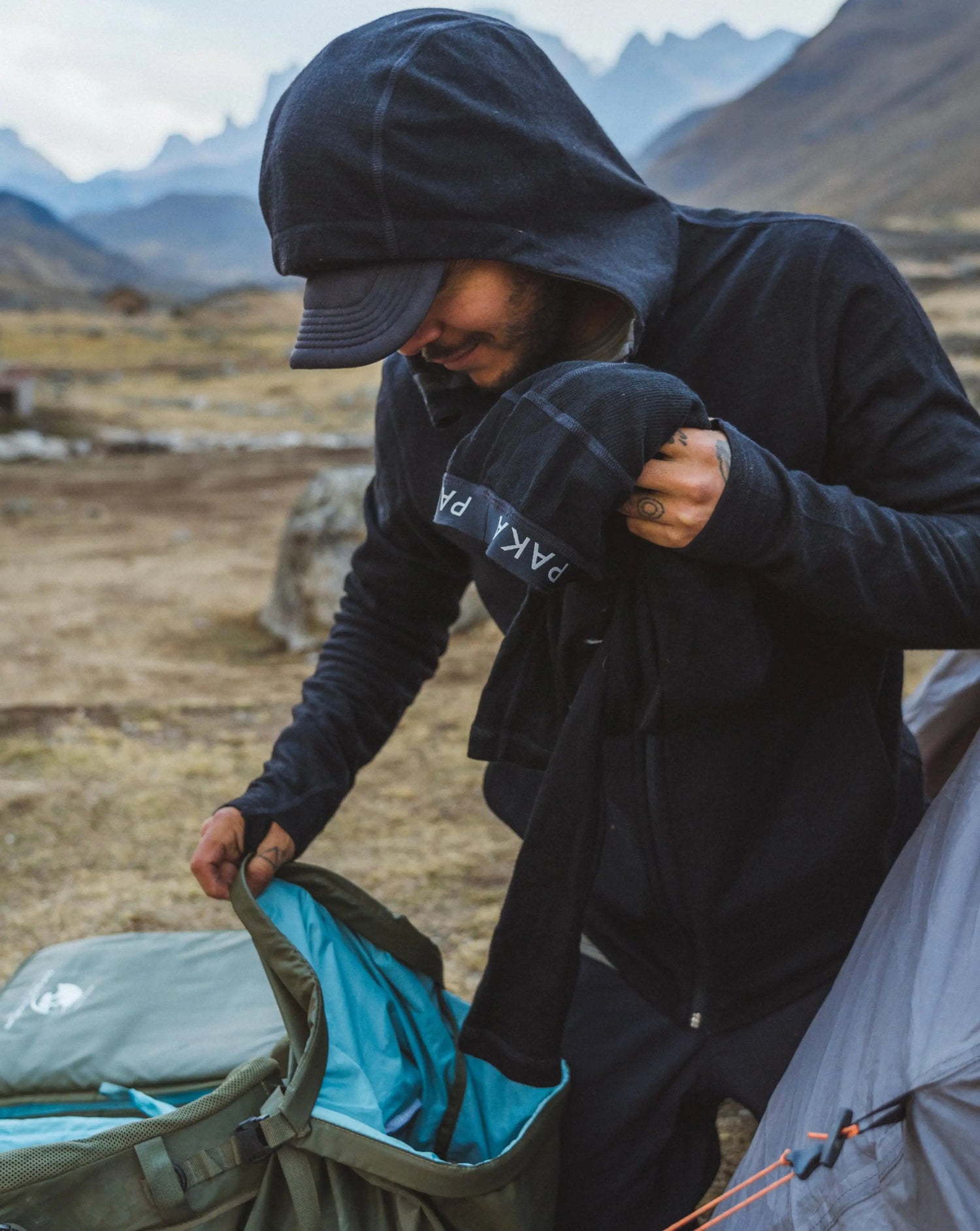 A man packing a black Men's Full Zip in the Andes Mountains