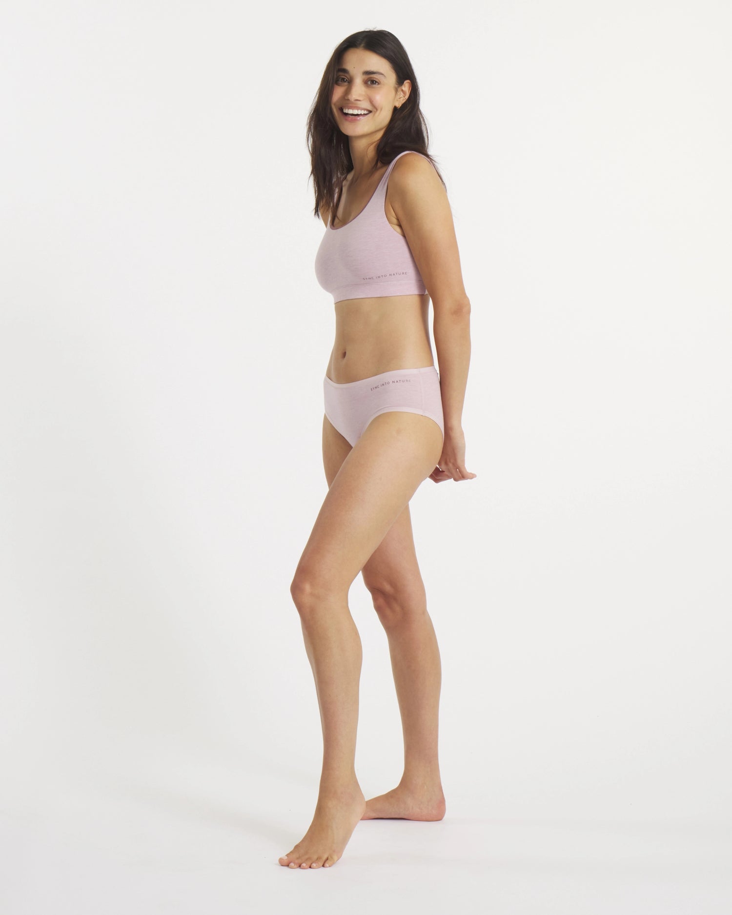 Woman wearing a light pink bikini set on a white background