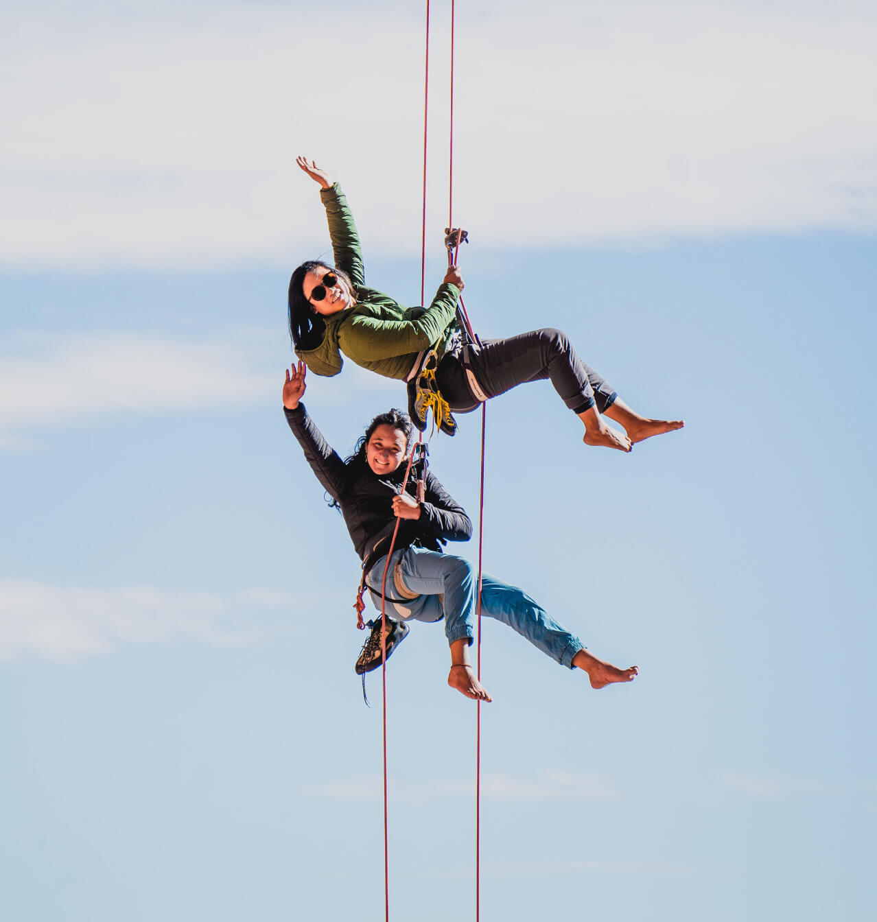 Climbers in jackets repelling on a rope 