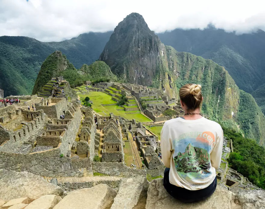 A woman wearing our Explore Peru Long Sleeve looking at impressing Machu Picchu