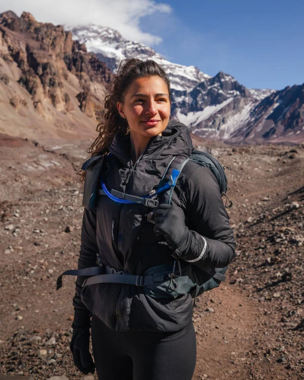 Woman Wearing Sustainable Apu Lightweight Puffer Jacket in Front of Mountains – PAKA Apparel