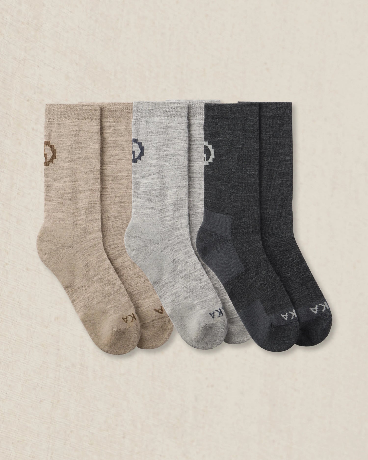 Three pairs of socks in beige, gray, and dark gray on a beige background
