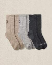 Three pairs of socks in beige, gray, and dark gray on a beige background