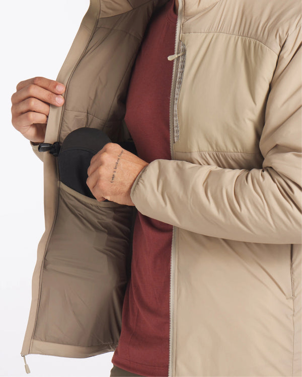 Man Removing Item from Side Pocket of Desert / Tan Apu Lightweight Puffer Jacket – PAKA Apparel