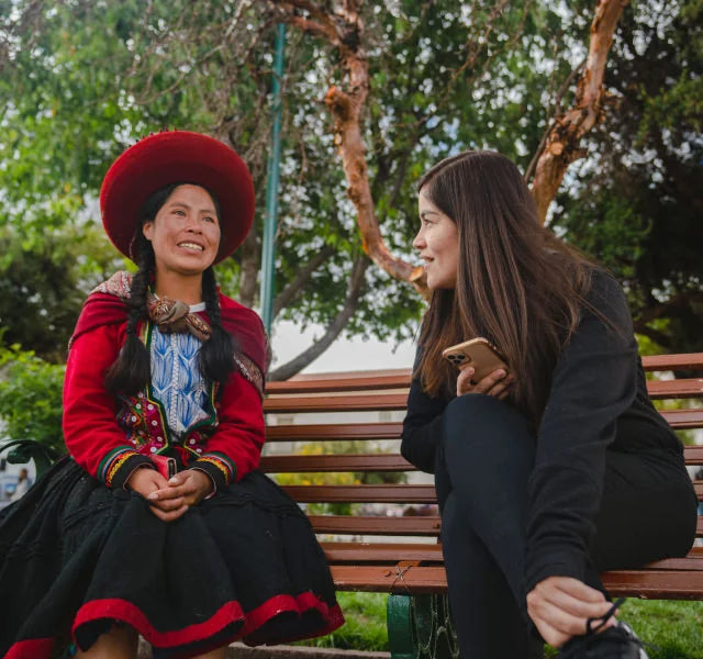 Gisella, our head of Peru and Noemi, one of our scholars wearing her traditional dress, talking in a park