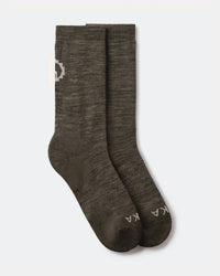 Flat lay of Essential Crew Socks in Andean Moss showing crew height, alpaca knit texture and PAKA logo on a light gray background