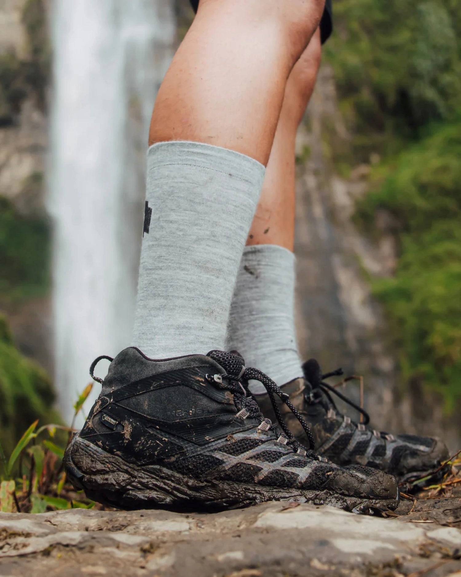 Person wearing hiking boots and light gray socks with a natural background