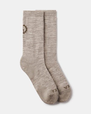 Flat lay of Essential Crew Socks in Timber showing crew length, alpaca knit texture, and PAKA logo on a light gray background
