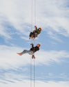 Two women suspended in mid-air on a rope