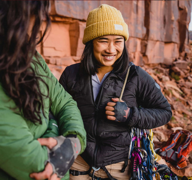 An experienced climber smiling in her black Pakafill puffer jacket