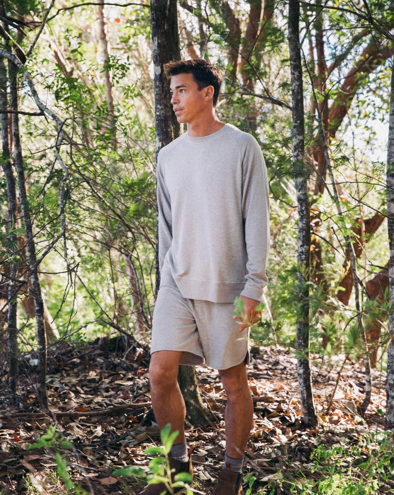 A guy standing in the nature, wearing our alpaca Terry garments in gray