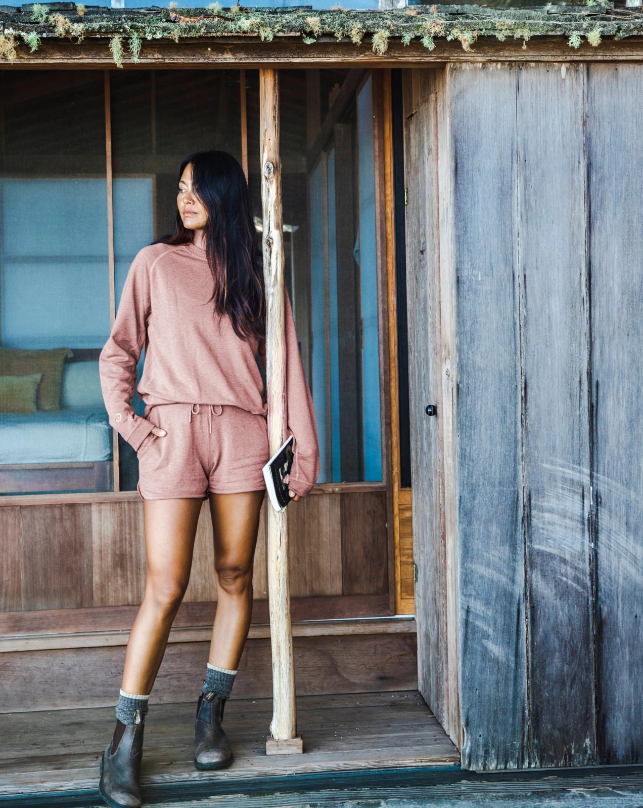 A lady wearing our alpaca terry garments in a wooden house 