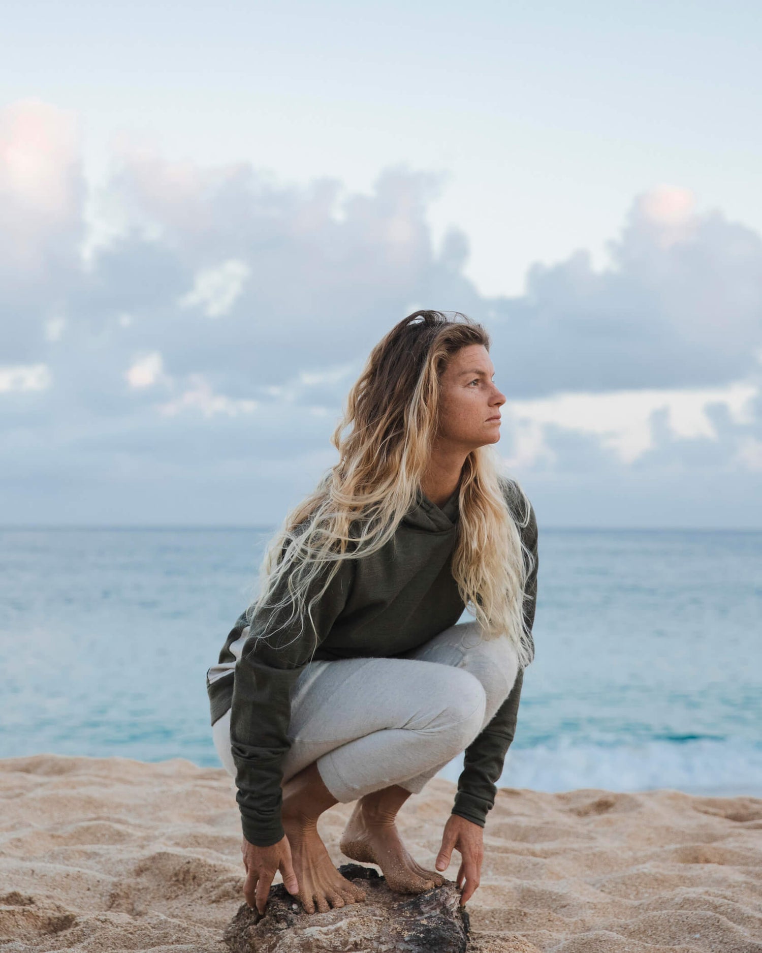 Woman crouching down in front of Ocean 
