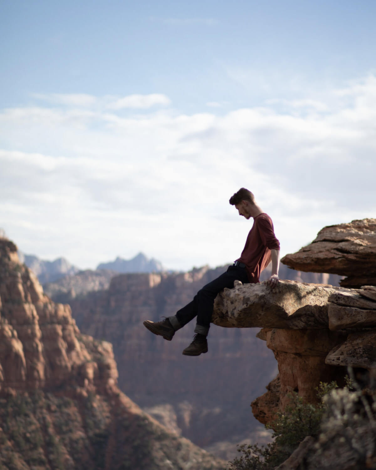 A man sitting on the edge of a rock in his alpaca baselayer