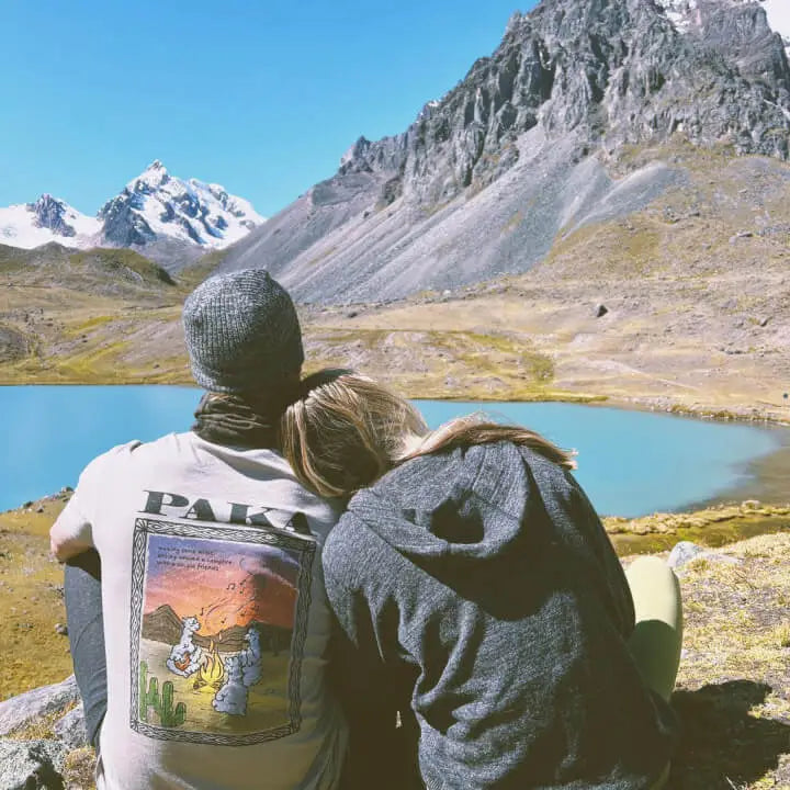 A couple looking at a mountain and a mineral blue lake