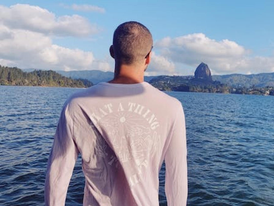 A man looking at the ocean in his lavender Sebastian Baselayer. It says "What a thing to be alive" in the back