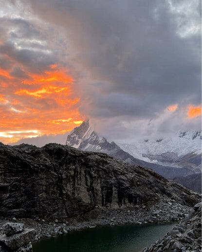 Mountain with orange sunset in background.