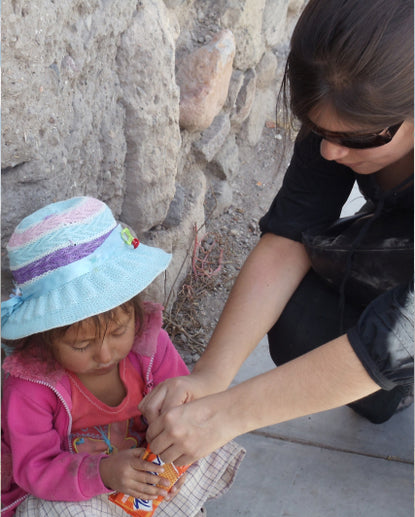 Gisella helping a girl open a package of cookies