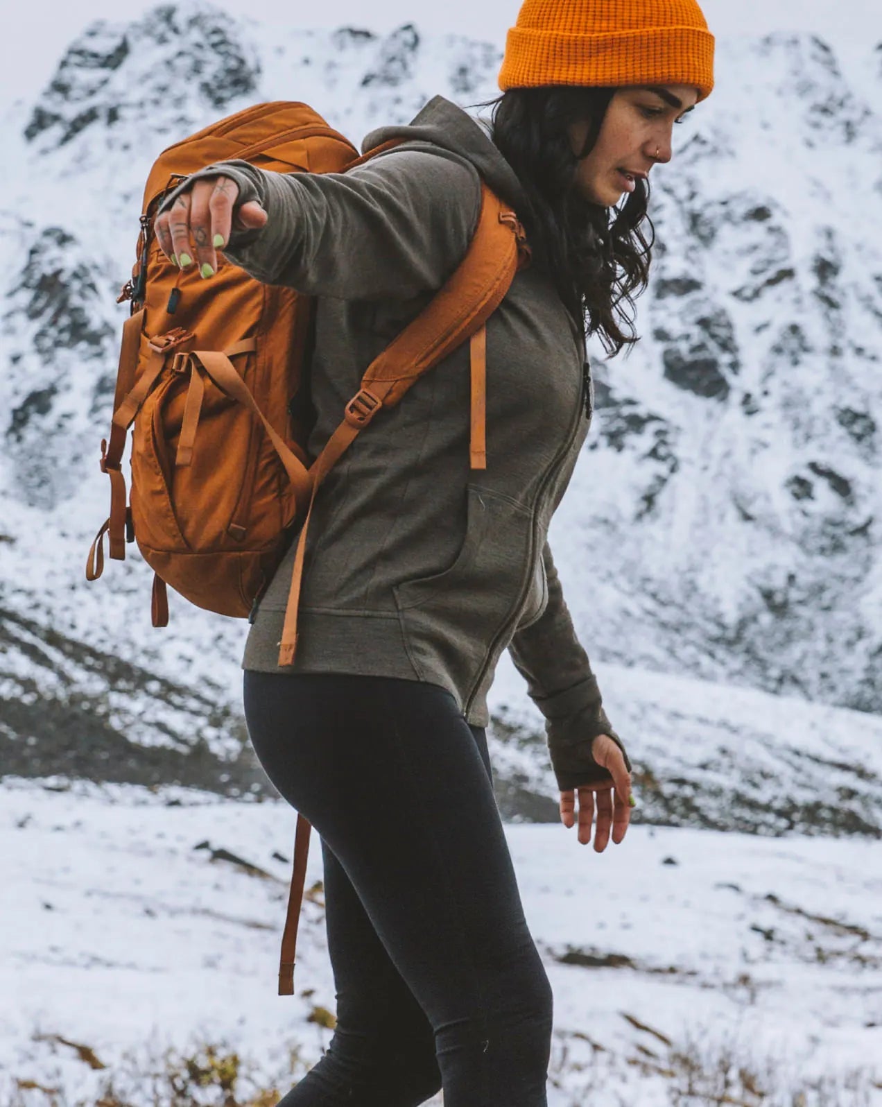 A woman wearing a green Breathe Women's Full zip in a snowy mountain