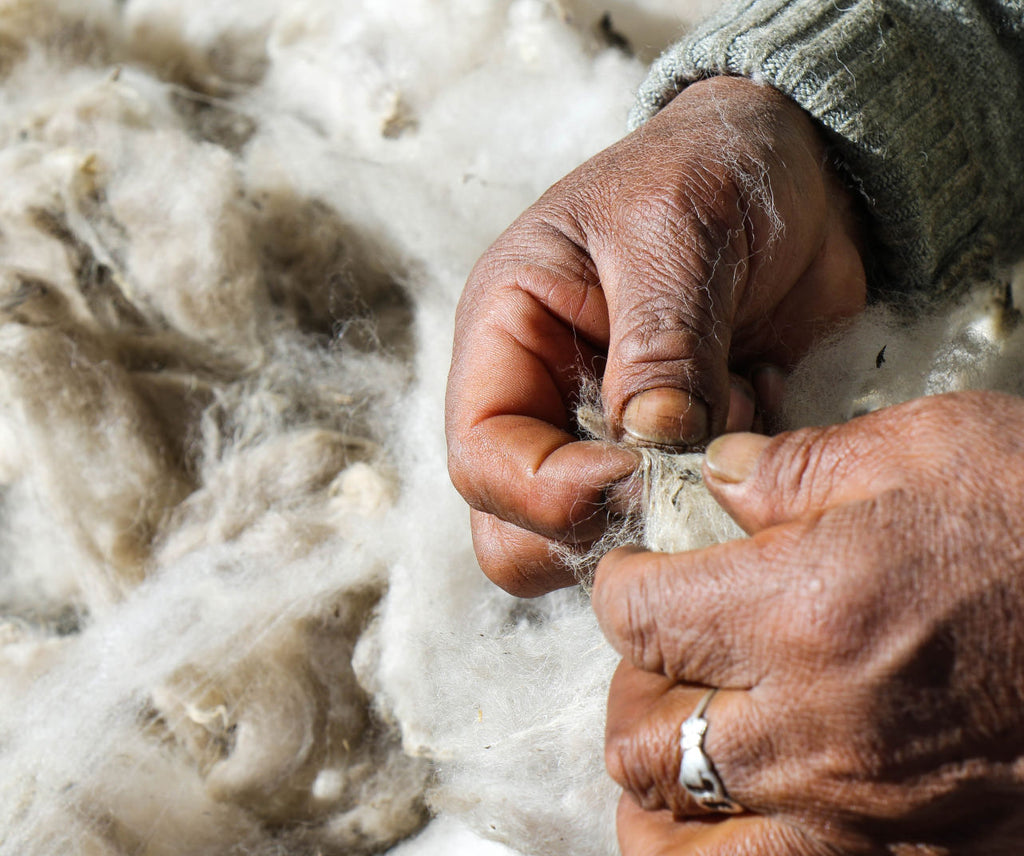 A quechua woman's hands holding the alpaca fiber