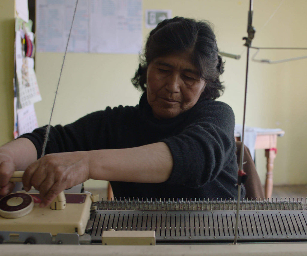 A peruvian woman hand knitting a sweater