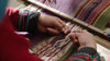 Hands of a Quechua woman weaving colorful blanket