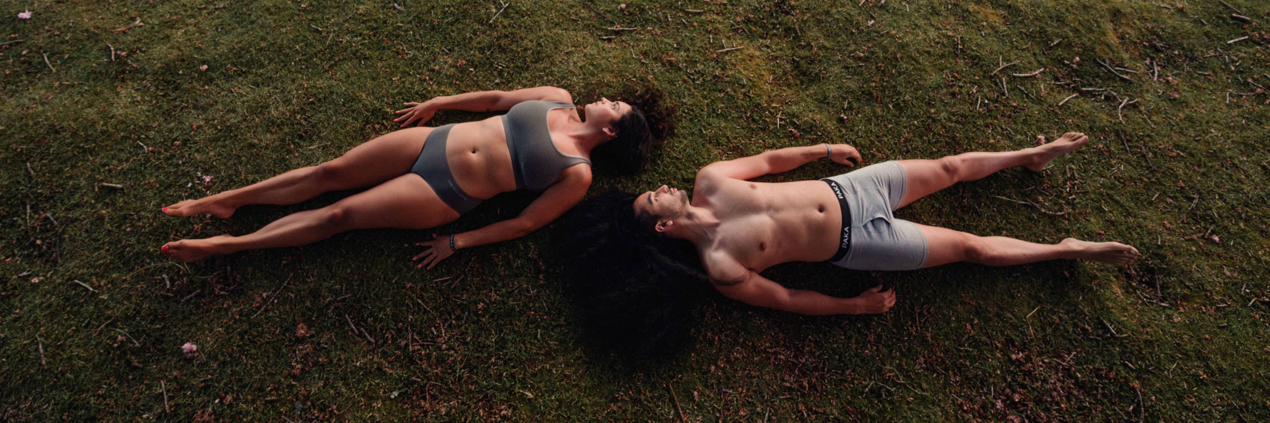 Overhead Shot of Man and Woman Wearing Sustainable Natural Fiber Alpaca Underwear While Lying ion Grass – PAKA Apparel