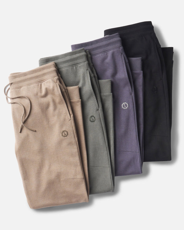 Folded Pairs of Natural Fiber Men’s Jogger Pants in Walnut / Tan, Forage / Grey, Stone Blue and Black – PAKA Apparel