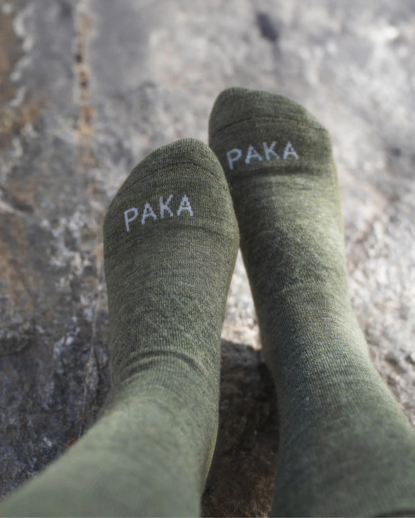 Close-Up of Dark Green / Eucalyptus Melange Alpaca Crew Socks on Feet on a Rock – PAKA Apparel