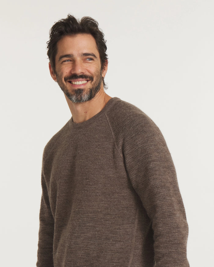 Man wearing a brown sweater against a white background