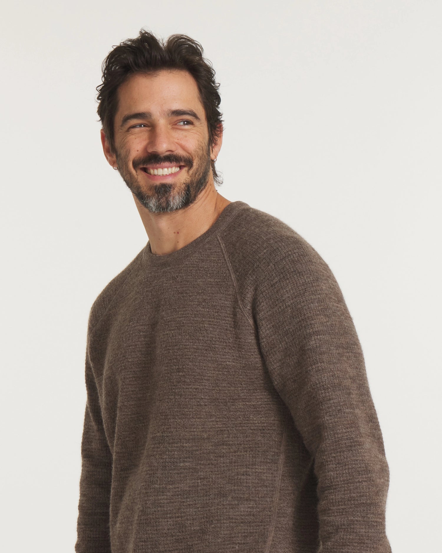Man wearing a brown sweater against a white background