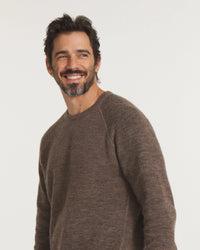 Man wearing a brown sweater against a white background