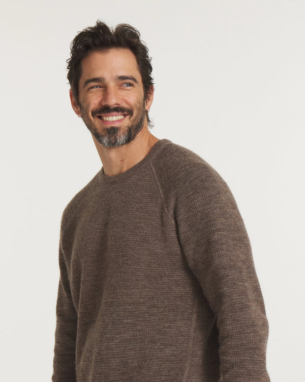 Man wearing a brown sweater against a white background