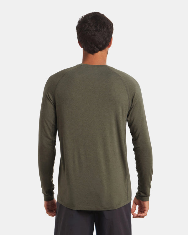 Person wearing a green long-sleeve shirt on a white background