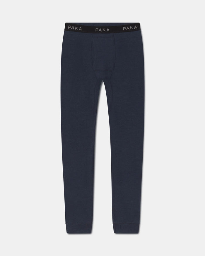 A pair of dark navy blue knit pants with a black elastic waistband featuring the brand name 'PAKA' printed in white, shown against a light gray background.