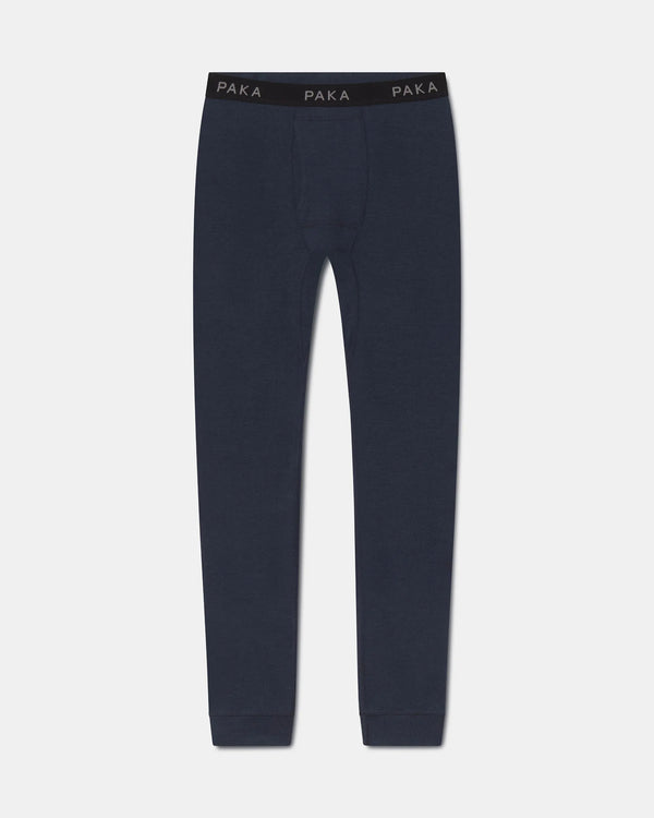 A pair of dark navy blue knit pants with a black elastic waistband featuring the brand name 'PAKA' printed in white, shown against a light gray background.