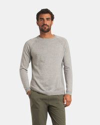 Front view of Men’s Ultralight Crew sweater in ice heather grey on model, lightweight knit with raglan sleeves and ribbed cuffs and hem