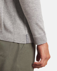 Side close-up of Men’s Ultralight Crew in Ice Heather Grey showing ribbed hem, woven side tag, and cuff with olive pants