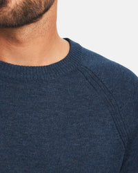 Close-up front of Men’s Ultralight Crew in navy showing ribbed crew neck, raglan shoulder seams, and fine knit texture on light gray background