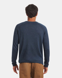 Back view of Men’s Ultralight Crew in navy on model showing raglan sleeve seams and ribbed hem against a light gray background