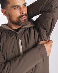 Male Model Zipping Arm Vents on Apu Wood / Brown Rainproof Parka Sustainable Winter Ski Jacket – PAKA Apparel
