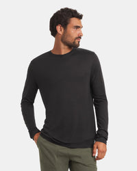 Three-quarter front view of Men’s Aire Long Sleeve shirt showcasing slim fit and crew neck in black on light gray background